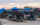 Visitors gather at picnic tables beneath blue umbrellas at Union Yards, an outdoor tailgate and event space adjacent to the Philadelphia Union's Stadium, Subaru Park, in Chester, Pennsylvania.