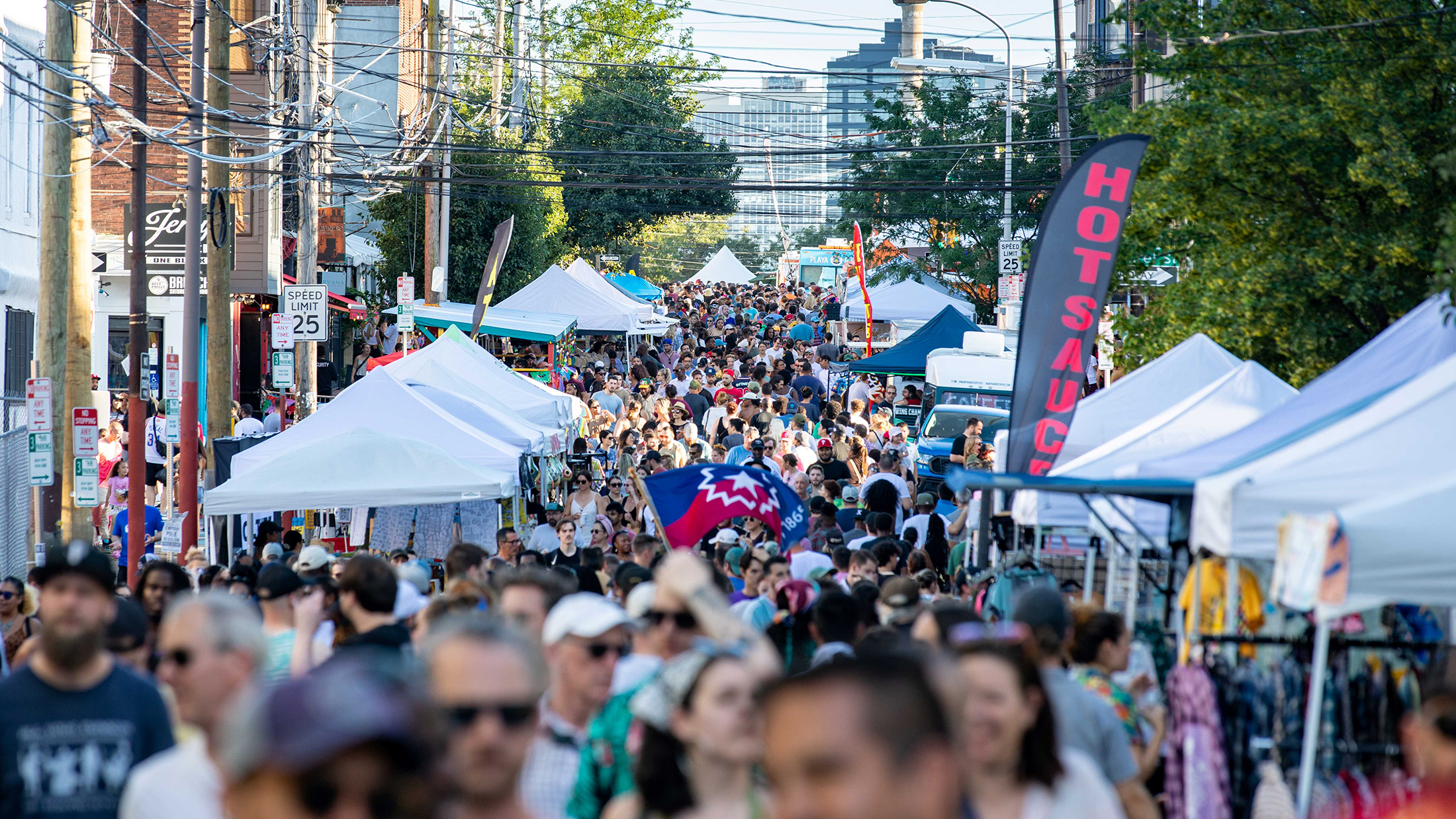 A large crowd fills North 2nd Street between rows of vendor tents and food trucks at the 2nd Street Festival in Northern Liberties.
