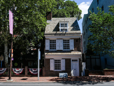 A front view of the Betsy Ross House, a preserved two story colonial home with white shutters and front door.