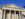 A close-up of First Bank's grand neoclassical facade featuring six large columns supporting a sculptured pediment.
