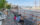 Visitors relax in white Adirondack chairs and cargo net hammocks overlooking the Delaware River, with the Benjamin Franklin Bridge and historic tall ship in the background.