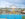 A wide view of Independence Blue Cross RiverRink Summerfest along the Delaware River Waterfront, featuring a blue roller skating rink, colorful Ferris wheel, arcade games and food stands.