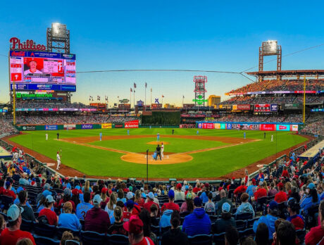 A panoramic view of a sold-out Citizens Bank Park during a Philadelphia Phillies game at sunset, with fans filling the stands as plays take the field beneath of clear evening sky.