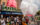 Crowds gather outside The Colonial Theatre during Phoenixville's BlobFest as participants in colorful costumes spray fire extinguishers into the air during the festival's signature parade, with the theater's iconic marquee in the background.