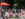 Crowds stroll along a car-free Walnut Street during Open Streets: West Walnut, while visitors dine beneath umbrellas and relax in lawn chairs set up in the roadway.