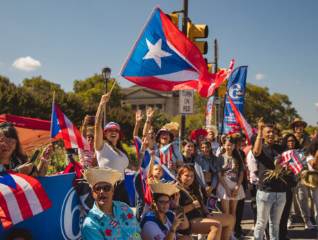 A lively crowd cheers and waves Puerto Rican flags along the Benjamin Franklin Parkway during Philadelphia's Puerto Rican Day Parade.