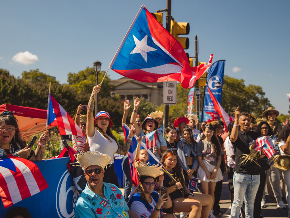 A lively crowd cheers and waves Puerto Rican flags along the Benjamin Franklin Parkway during Philadelphia's Puerto Rican Day Parade.