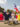 Dancers in flowing red, white and yellow costumes perform a traditional dance along the Benjamin Franklin Parkway as a participant carries a large Puerto Rican flag overhead.