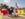 Dancers in flowing red, white and yellow costumes perform a traditional dance along the Benjamin Franklin Parkway as a participant carries a large Puerto Rican flag overhead.