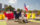 Dancers in flowing red, white and yellow costumes perform a traditional dance along the Benjamin Franklin Parkway as a participant carries a large Puerto Rican flag overhead.
