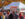 Festivalgoers lined up beneath a large white vender tent selling apple fritters during Peddler's Village Apple Festival, surrounded by vibrant autumn foliage.