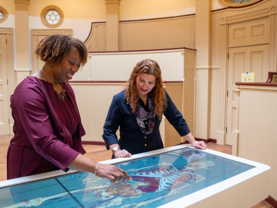 Deux personnes explorent un modèle anatomique numérique du corps humain sur une table interactive Anatomage au sein du musée de l'hôpital de Pennsylvanie.