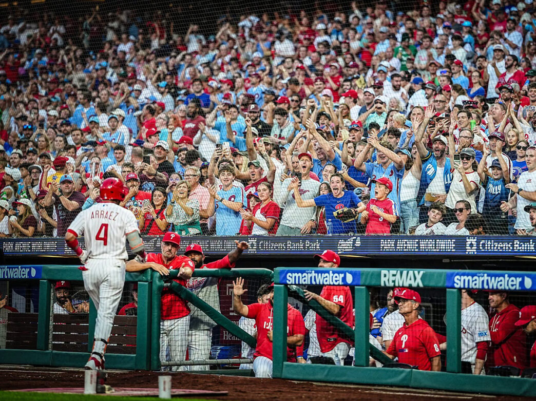 Philadelphia Phillies fans cheer from the stands behind the team's dugout as a Phillies player approaches dugout during a game at Citizens Bank Park.