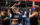 Una persona baila alegremente con una bandera arcoíris en cada mano entre una multitud de personas en el OURFest de Filadelfia.