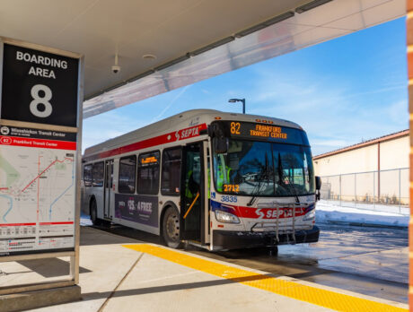 A SEPTA Route 82 bus bound for Frankford Transit Center waits at a boarding area on a sunny winter day.