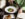 A diner wearing a green sweater pours red wine into a stemmed wine glass alongside artfully plated dishes and a dinner menu at Fond.