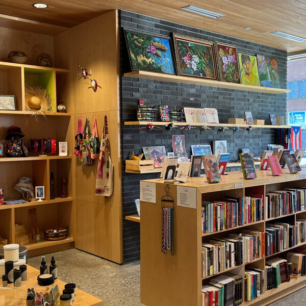À l'intérieur de la librairie « Julia de Burgos » du Taller Puertorriqueño. Les livres sont disposés sur des étagères, et d'autres produits sont exposés à proximité.