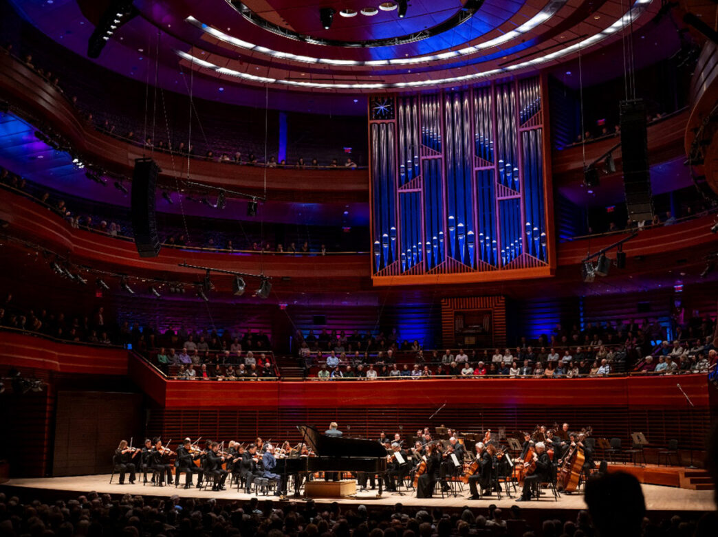 The Philadelphia Orchestra performs in Marian Anderson Hall at the Kimmel Center beneath the venue’s towering organ pipes.