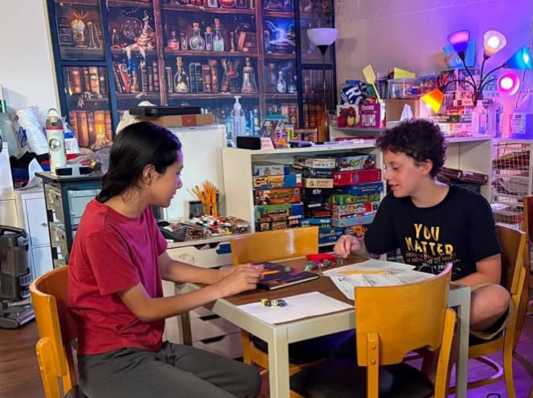 Two children play an intense board game at Queen & Rock Game Cafe in Society Hill.