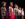 A group of children wearing animal ears and costumes stand in a row under stage lights during a youth theater performance.