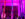 Aerial performers wearing black-and-white striped tights hang upside down from colorful silks beneath vivid pink and purple lighting.