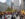 A colorful Ferris wheel rises above busting holiday market stalls, where visitors browse vendors beneath illuminated star decorations and surrounding Center City Buildings.