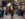 A person wearing a yellow crop top, black jacket, black pants and sunglasses struts through the street while a crowd cheers on during OurFest in Philadelphia.