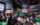 A packed crowd of Philadelphia Eagles fans cheer with their arms raised while watching a football game on a giant screen.