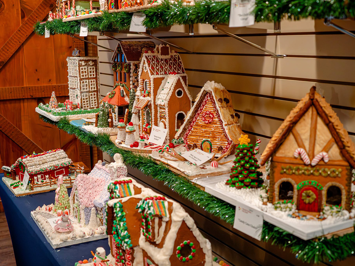 An assortment of elaborately decorated gingerbread houses featuring colorful candies, icing and festive details.