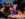 A young girl in a purple Halloween dress decorates a pumpkin alongside an adult at a festive craft table during Manayunk Fall Fest.